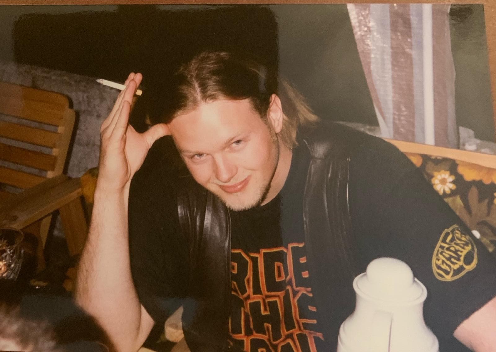 Ung mann med langt hår og sigarett bak øret ser i kamera